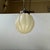 Art Deco or Bauhaus era styled hanging lamp featuring a pumpkin style fluted shade in blonde/beige opaline glass in a...