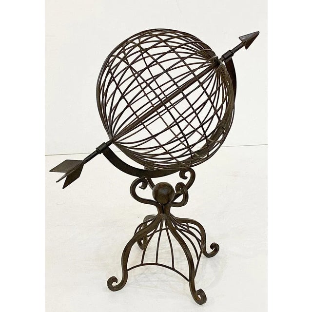 A fine French armillary sphere or decorative garden ornament of wrought iron featuring an arrow positioned in a globe...