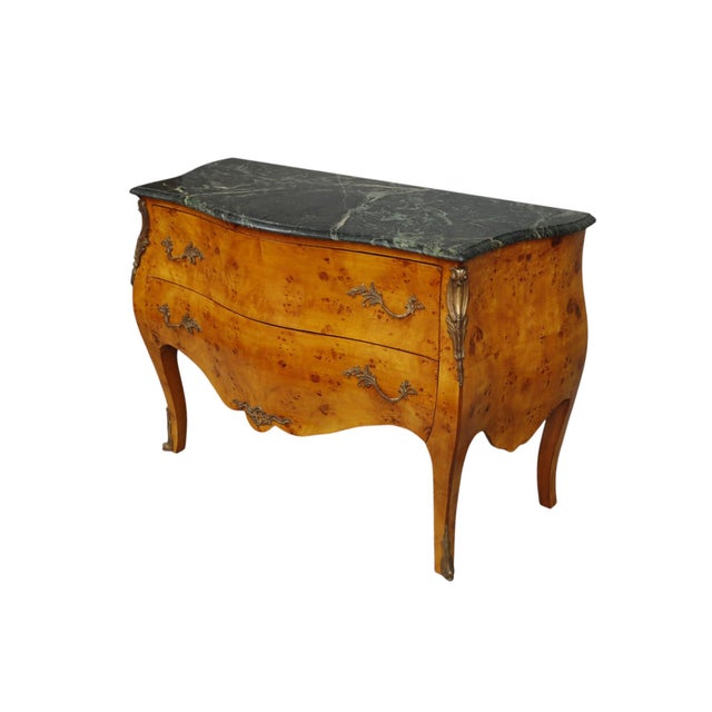 A 20th century bombe commode in the Louis XV style. Hand crafted in Germany by Casa Padrino with book matched birdseye...
