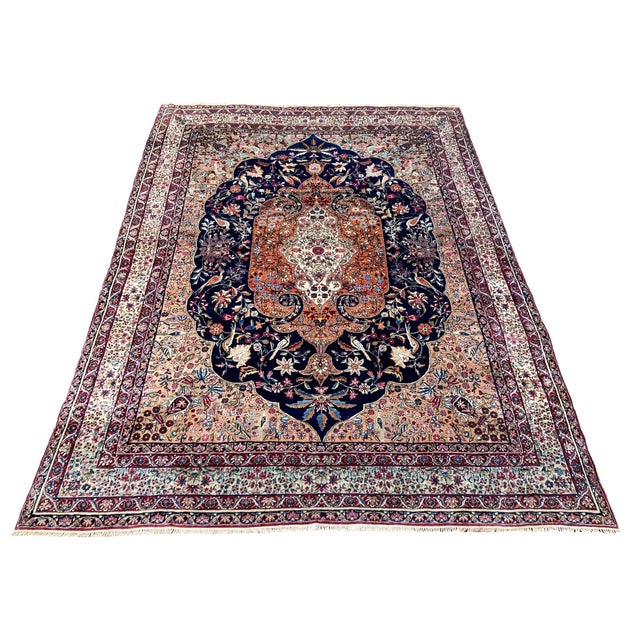 A fabulous antique Kirman Lavar carpet, woven circa 1910. The design features a large floral medallion on a deep indigo...