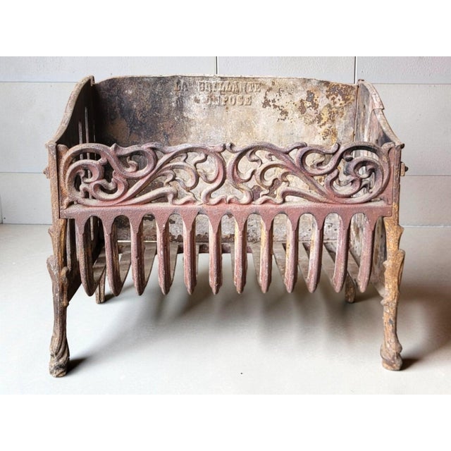 Cast iron log holder/fireplace basket Height 31 cm Width 38 cm Depth 21 cm Note a break on the right and a crack on the...