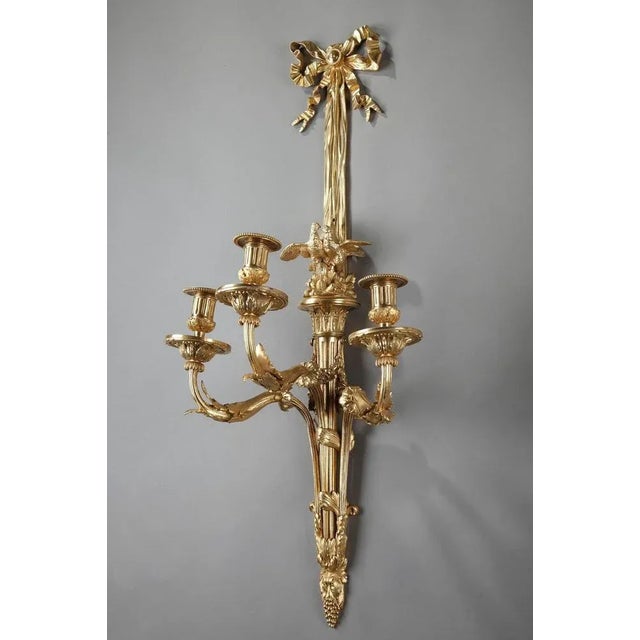 Pair of louis xvi-style wall sconces crafted entirely of gilded bronze, with three-light decorated with acanthus leaves....