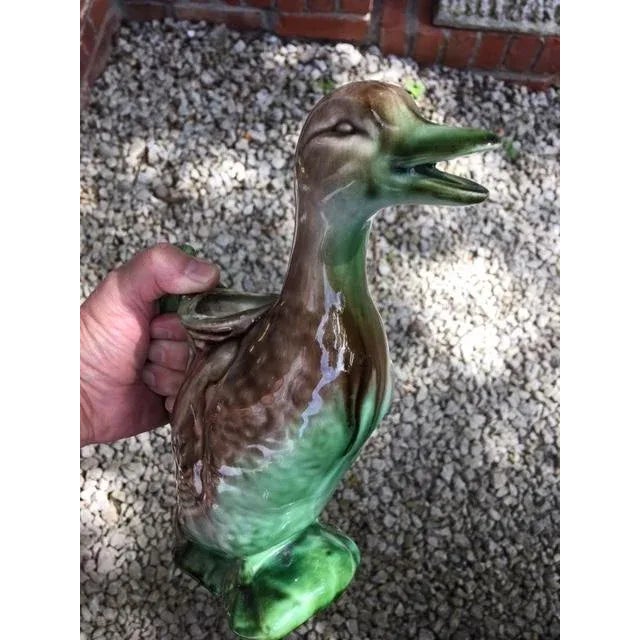 Very nice piece of Majolica that is the deep rich green and brown glaze. It's a duck! He's a pitcher! His mouth is the...