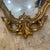Elegant gilt wall mirror by Syroco Inc., with an ornate Rococo Revival-style frame of scrolls, florals, and acanthus...