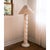 A sculptural floor lamp with a tall, twisting plaster column and rounded base in a soft ivory finish. Its textured surface...
