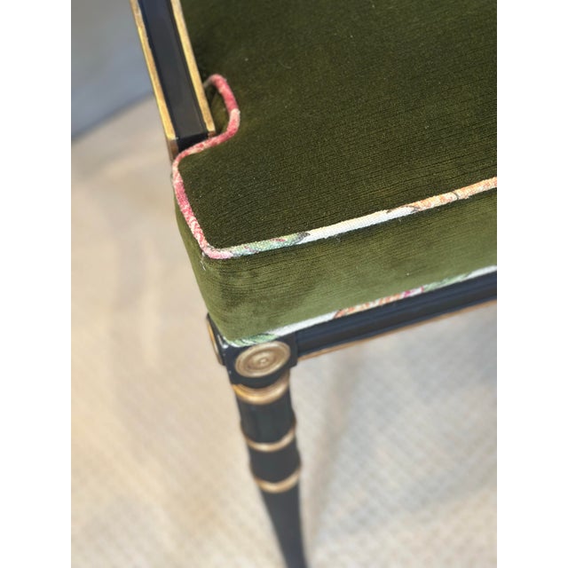 A beautifully proportioned antique Regency-style armchair, distinguished by its elegant ebonized frame, classical gilt...