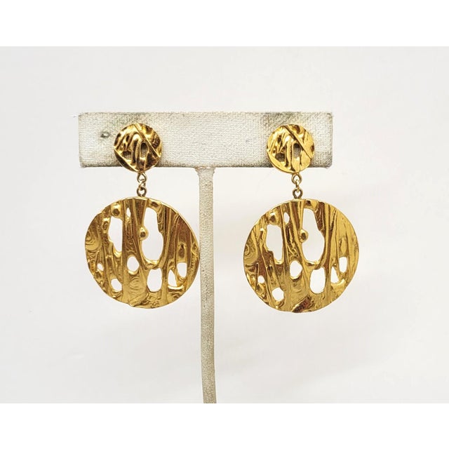 This is part of Chairish’s Costume Jewelry assortment. 1970s Modernist goldtone round smaller tops with larger round...