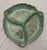 A vibrant mottled mint green color highlighted by gold accents highlights three (3) intricate leaf-shaped sections. A...