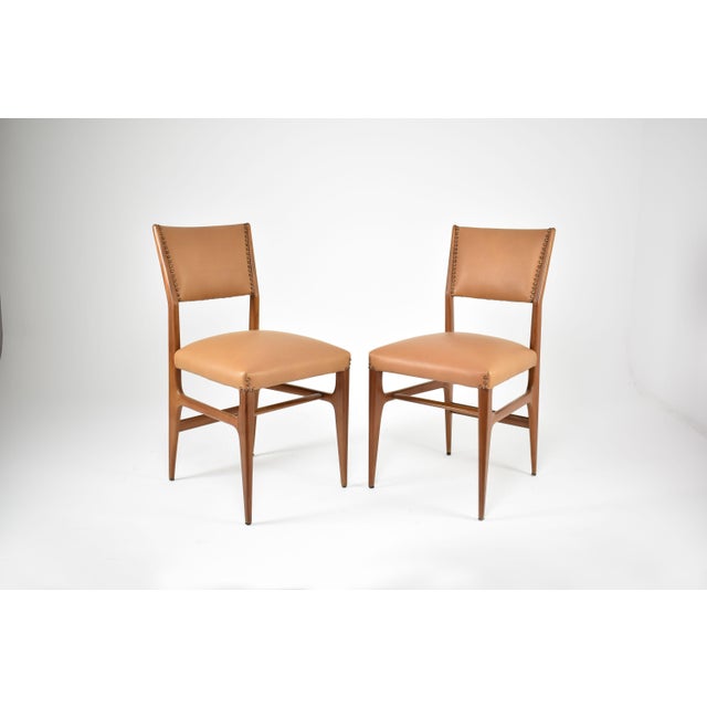 A pair of Italian side chairs by Gio Ponti, from to the 1950s mid-century period in walnut with restored in a beautiful...