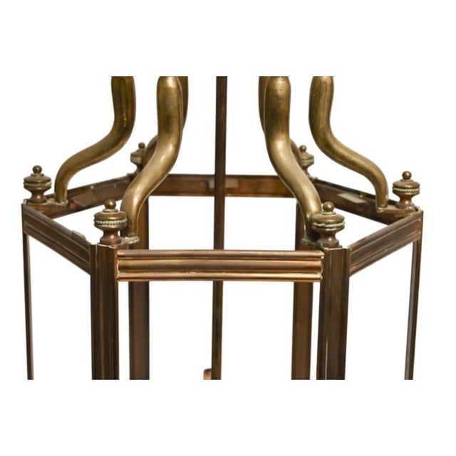 A large antique brass entryway or hall lantern with an aged golden-brass patina, hexagonal glass-paned frame, arched and...