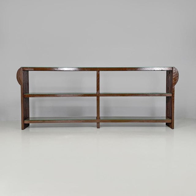 Italian modern bookcase with brown wood slats structure and glass shelves, 1970s Elongated bookcase with two bays. The...