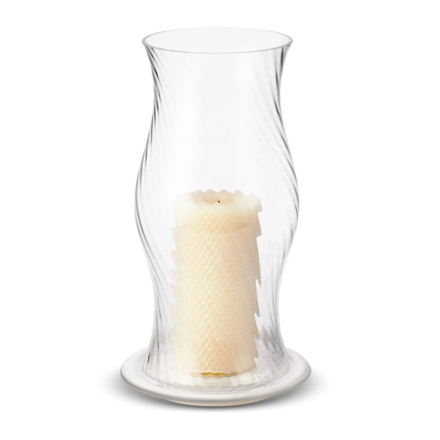 Inspired by vintage glassware, these glass hurricanes have a fluted form enhanced with a curving pattern. The mouth-blown...