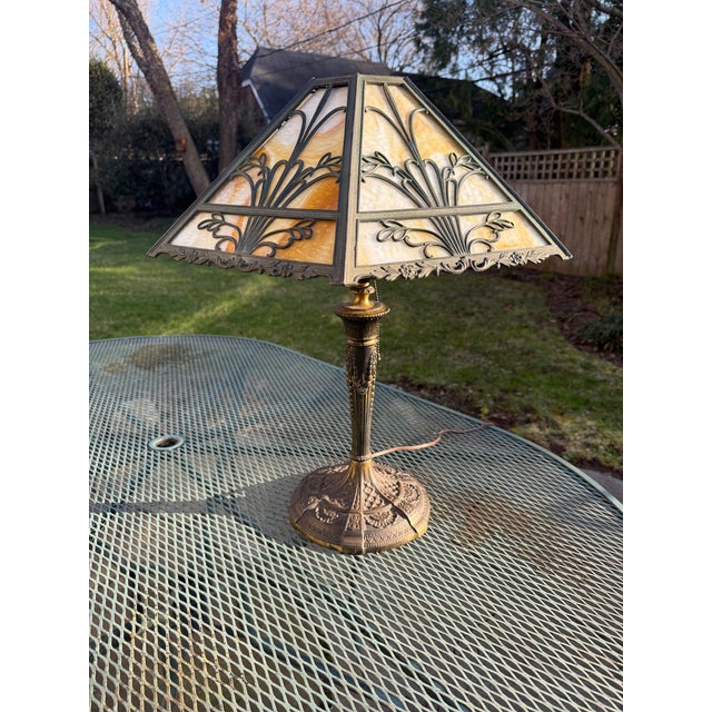 Gorgeous early 20th century American Art Nouveau table lamp with 6-panel caramel slag glass shade. The shade features...