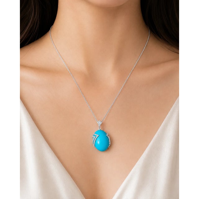 This elegant pendant necklace is crafted in 14K white gold and features a striking oval turquoise accented with shimmering...