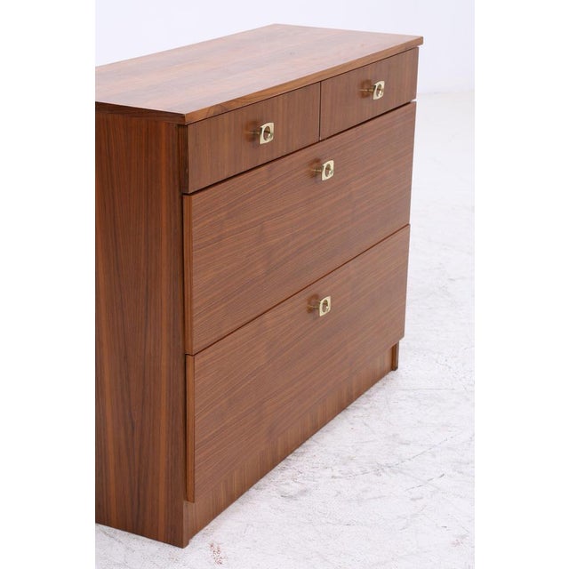 Vintage shoe cabinet from the 1960s with two drawers and spacious drop-down compartments. The clean lines and beautiful...