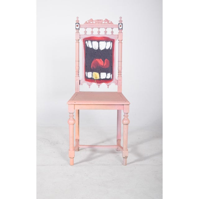 Painted chair with teeth and tongue on the back. With a turned structure and decorative carvings on the backrest,...