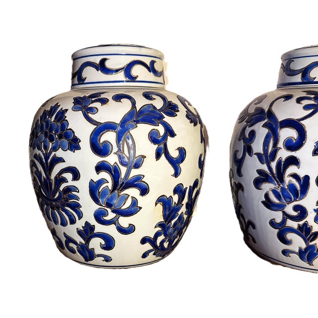 Vintage pair of traditional Chinese chinoiserie ginger jars - a pair. These porcelain jars feature a hand-painted vibrant...