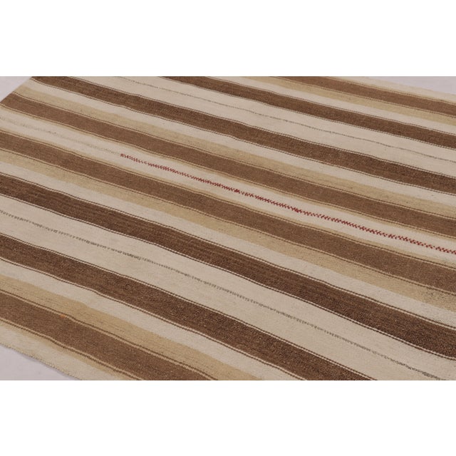 Made with handwoven wool circa 1950-1960, this 5x5 vintage square flat-weave Kilim is a particularly serene and sought-...