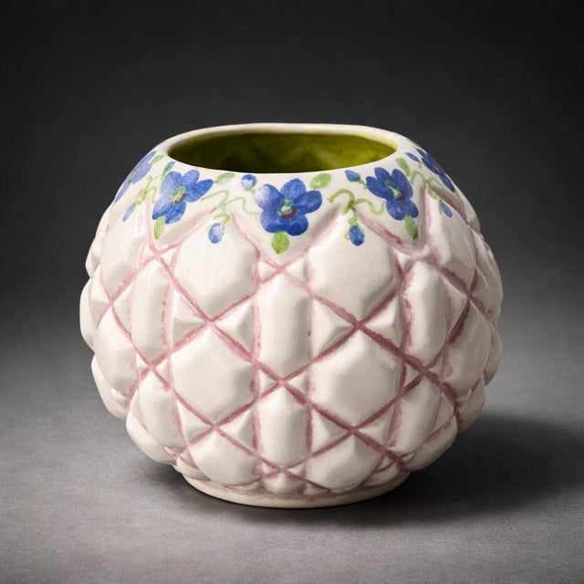 A charming and highly textural handcrafted ceramic vase featuring a sculptural faceted body with soft pink lattice...