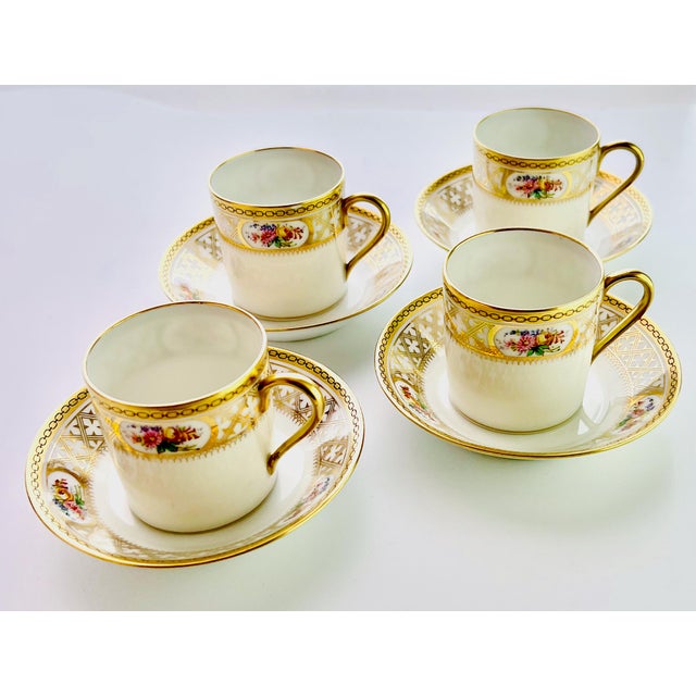 An exquisite elegant set of four antique demitasse coffee cans and matching saucers, crafted in fine porcelain with...