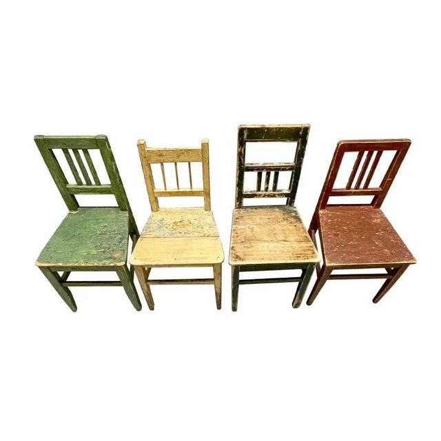 A set of charming painted side chairs. Heavily distressed with straight open backs, flared seats, and square-angled legs....