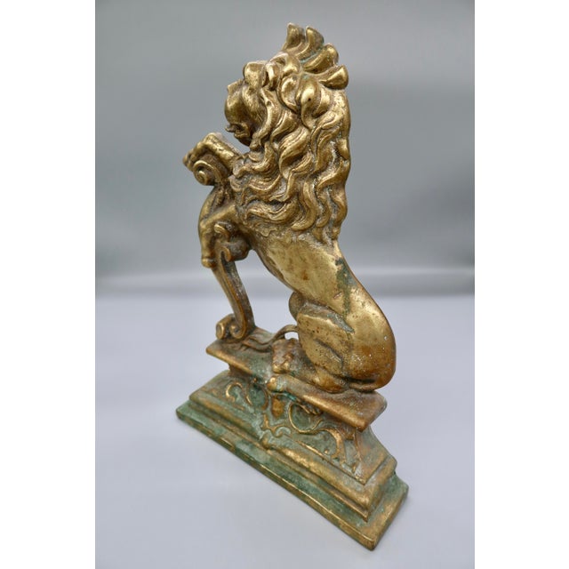 A large and beautifully detailed hollow cast brass lion in the classic heraldic rampant pose — one paw resting on an...