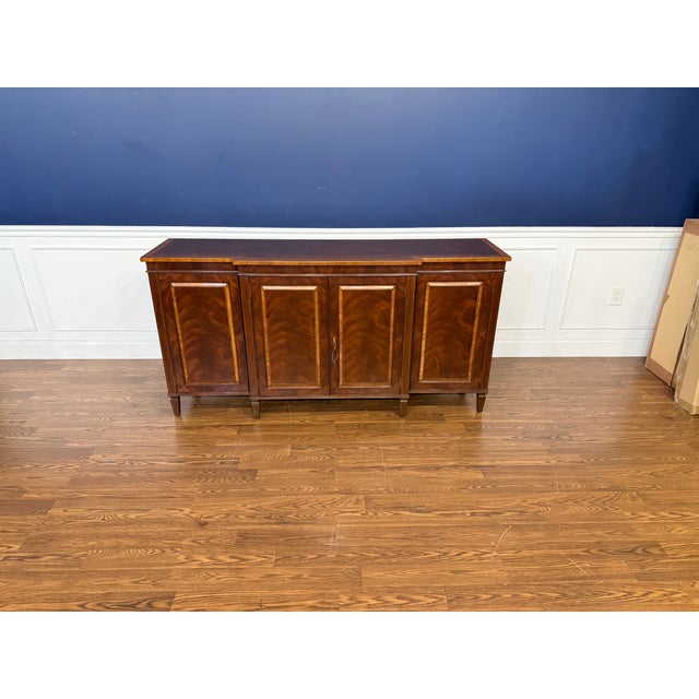 This is a Mahogany Hepplewhite Buffet by Leighton Hall. It features four lockable doors with adjustable shelves and a...