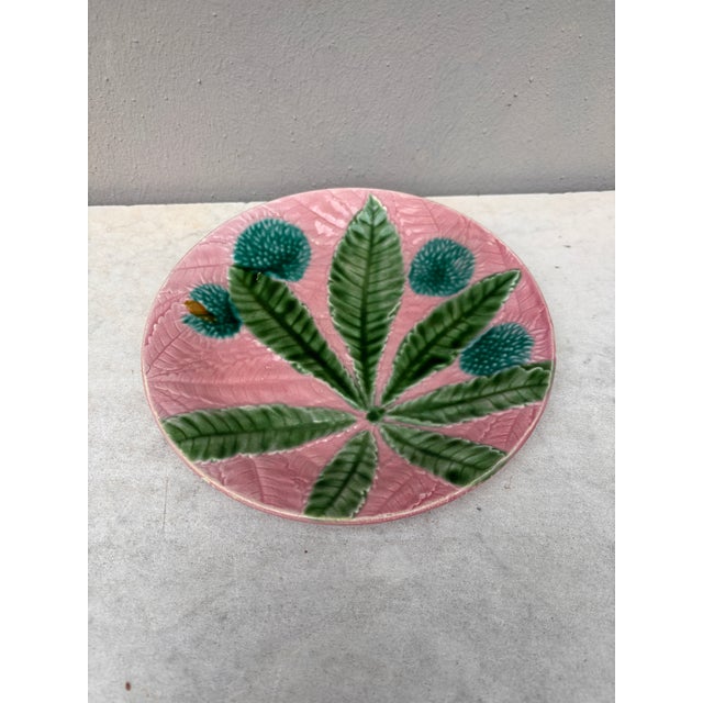 Majolica chestnut leaves plate Salins, circa 1880, on a pink background.