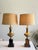 A pair of neoclassical-style brass table lamps featuring classic urn-form bodies with pierced decorative collars, set on...