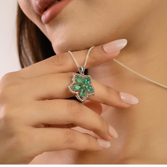 A perfect expression of love and elegance, this 925 Sterling Silver Emerald & Diamond Pendant showcases five finely cut...