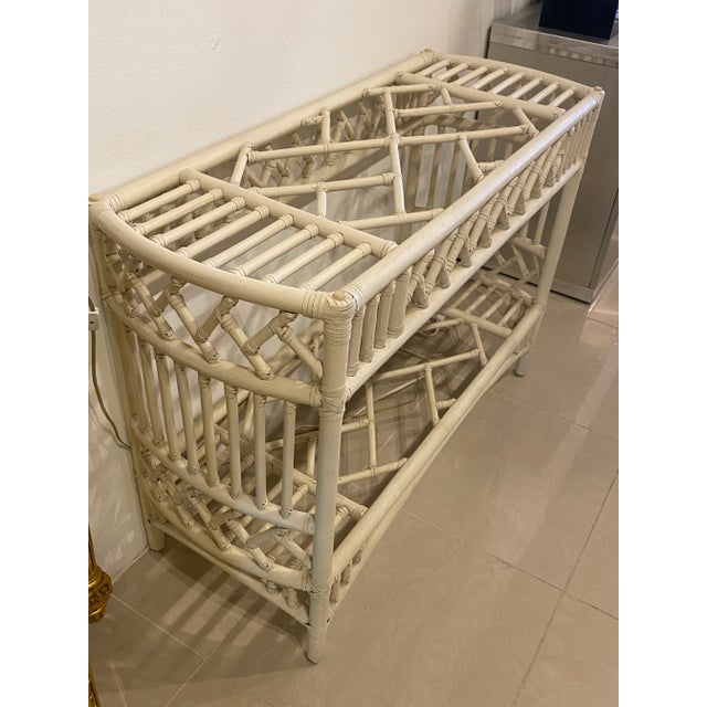 Vintage rattan Chinese chippendale Ficks Reed console table with glass top. Original cream paint and glass top may have...