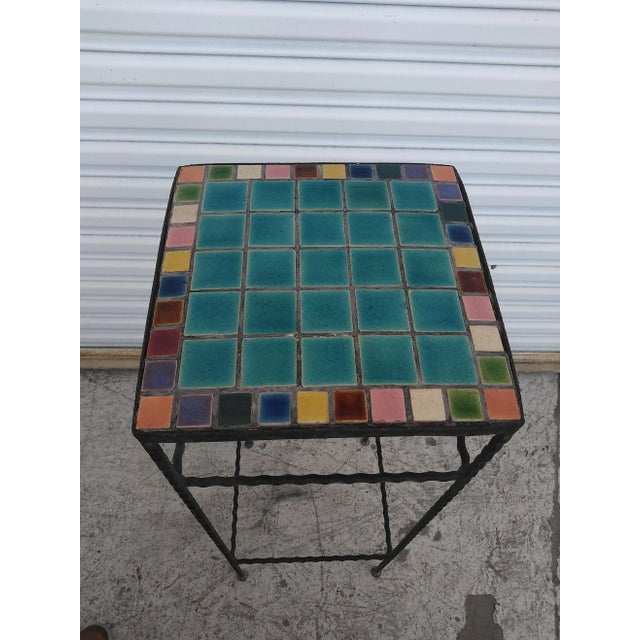 This is a wonderful wrought iron Mosaic tile top pedestal table. It features a braided or twisted form of wrought iron...