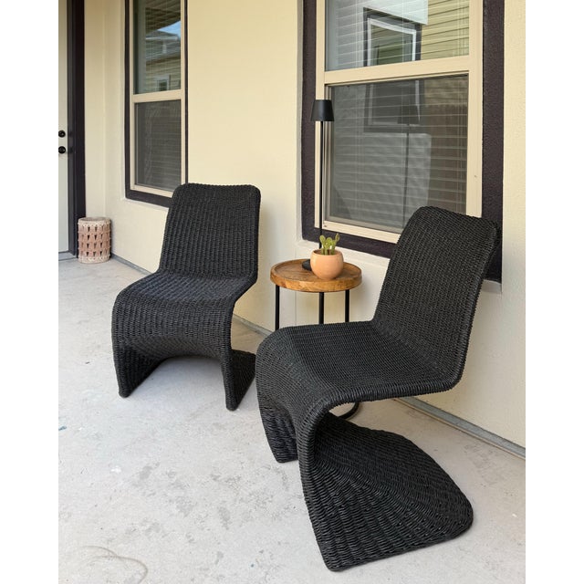 Pair of Arhaus Leon Outdoor Dining Chairs in the Bohemian Black finish. These sculptural chairs feature a sinuous S-shaped...