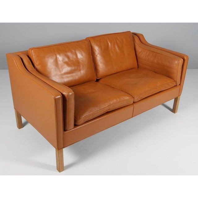Børge Mogensen two-seat sofa with original cognac leather upholstery. Legs of oak. Model 2212, made by Fredericia...