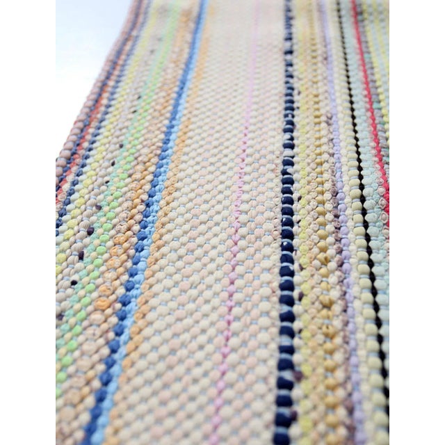 This is a vintage hand-loomed accent rug. The farmhouse throw rug features a pastel striped pattern with buttery yellows,...