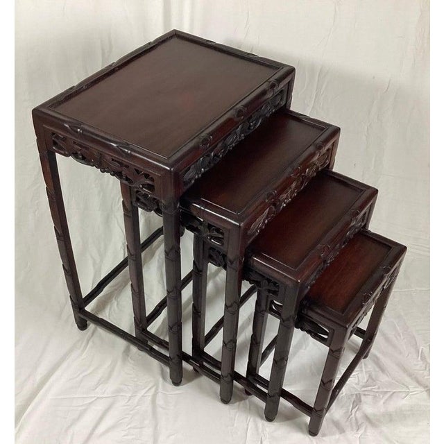 Chinese Rosewood set of 4 nesting tables with carved Frieze Decoration. The largest is 14" deep by 19.75" wide by 28"...