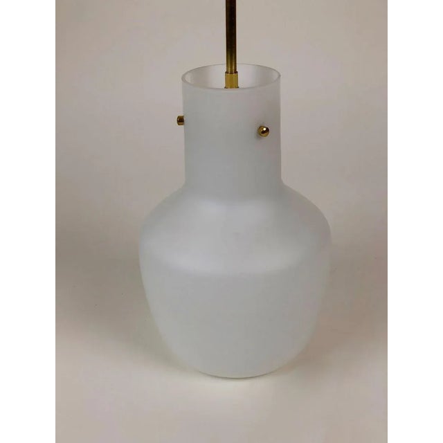 A simple, elegant pendant lamp from j.t. Kalmar. The lamp is composed of an opaline, matte white glass shade attached to a...