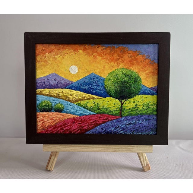 The oil painting on cardboard titled ""Summer Sunset Over Flowering Slopes"" captures the serene yet vibrant atmosphere of...