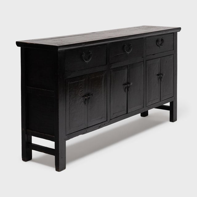 This antique coffer from China's Shanxi province has a simple, clean-lined form and a striking finish of dark lacquer. The...
