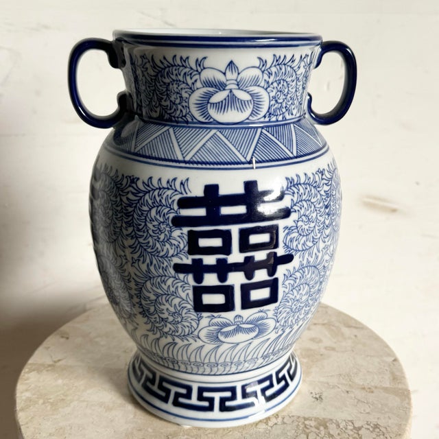 This classic blue and white Chinese vase draws inspiration from the Qing Dynasty, featuring intricate floral motifs and...