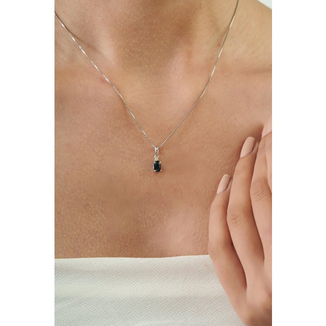 The Elegant Oval Blue Sapphire & Diamond Solitaire Pendant features a beautiful 0.67-carat Blue Sapphire in a classic 4 x...