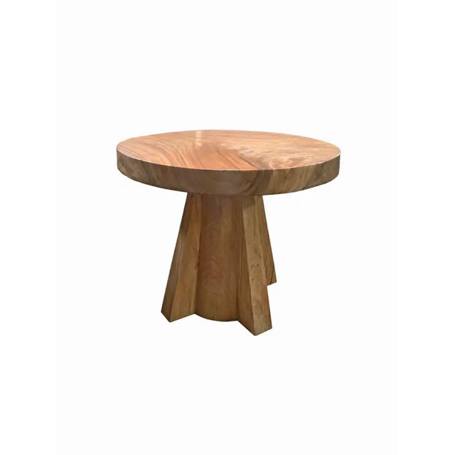 A wonderfully sculptural round side table. Crafted from solid suar wood with wood textures and shades throughout. The...