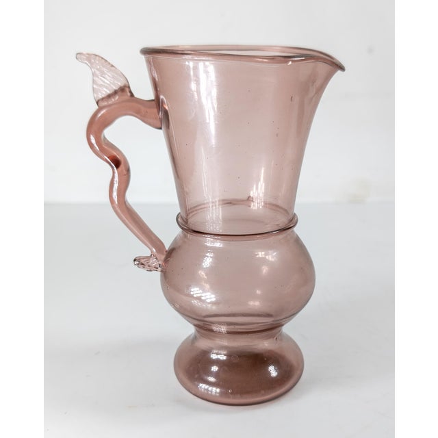 We are selling this interesting purple Amethyst glass. This glass or pitcher has simple elegant form with applied handle...