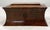 An early 19th century mahogany tea caddy. Of shaped rectangular form. The hinged cover opening to reveal a cut glass...