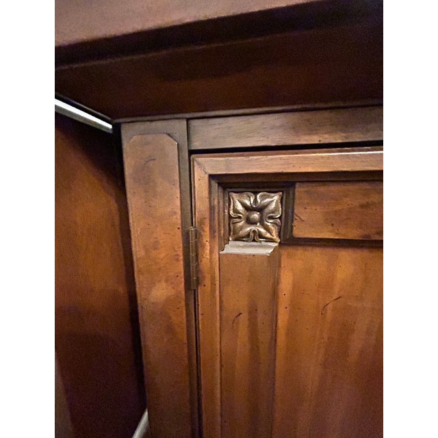 Elegant vintage-style buffet cabinet featuring rich warm wood tones, carved accent details, and a timeless classic design....