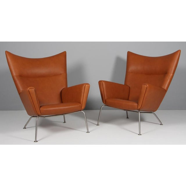Hans J. Wegner lounge chair / wing chair new upholstered with full grain aniline leather. Frame of brushed steel. Model...