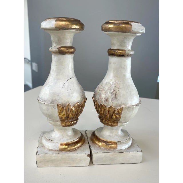 Elegant pair of vintage Italian-style candlesticks featuring classic urn-form silhouettes with distressed whitewashed...