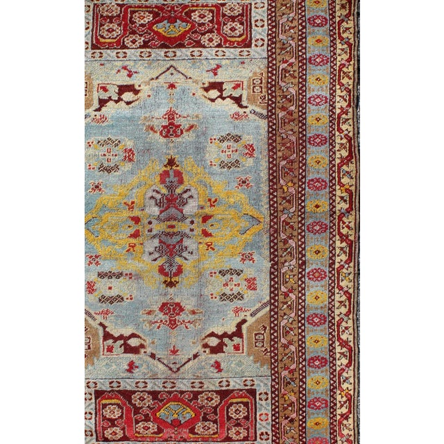 Medallion Design Antique Turkish Oushak Rug with Vibrant Color Palette in light blue, red, yellow/gold and brown....