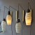 Two pairs of wall-mounted pendants with opaline shades hand painted in black hanging of black braided flex on an...