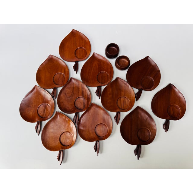 A striking mid-century Caribcraft serving set comprising 11 apple-shaped snack plates and two small cups, handmade in...